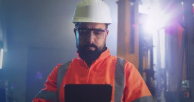 Fabrikada tablet kullanan erkek mühendis.