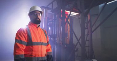 Fabrikada çalışırken kendinden emin bir mühendis.