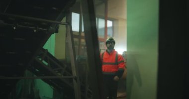 Erkek mühendis taşıma bantları altında makineleri inceliyor