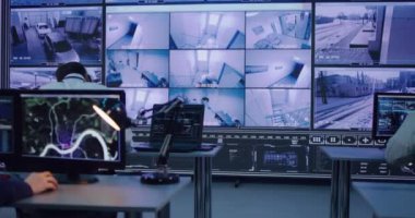 Çalışanlar güvenlik merkezinde kamera görüntülerini izliyorlar.