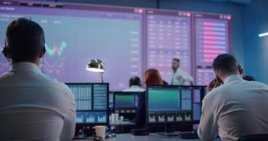 Borsada bilgisayar kullanan bir erkek tüccar.