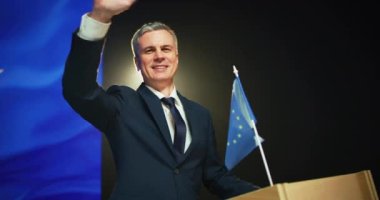 Neşeli politikacı podyumdan seyirciyi selamlıyor