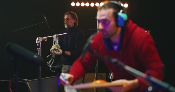 Коллеги-мужчины создают различные звуки для кино в студии — стоковое видео