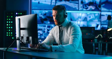 Gözetim merkezinde bilgisayar kullanan bir erkek operatör.