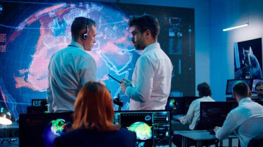 Erkek ekologlar ofiste tabletle ilgili verileri tartışıyor