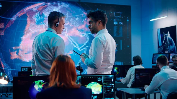 Erkek ekologlar ofiste tabletle ilgili verileri tartışıyor