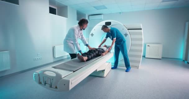 Erkek doktorlar kıdemli hastalara CT taraması yapıyor. — Stok video