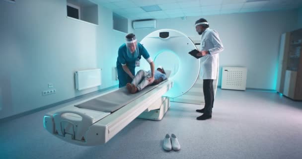 Médecins faisant CT scan de patient noir — Video