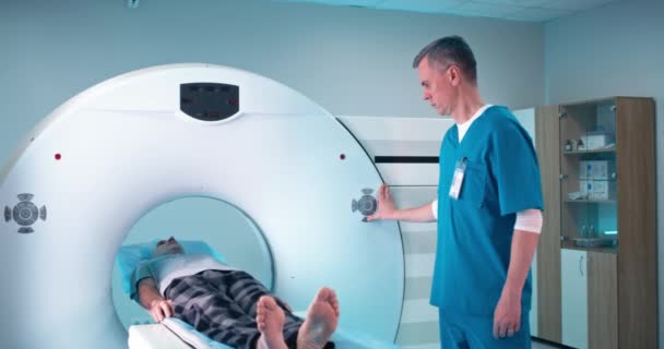 CTスキャンの終わりに患者を見て成熟した医師 — ストック動画