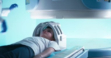 Eldivenli ekin doktoru çocuğun MRI taramasına başlıyor.