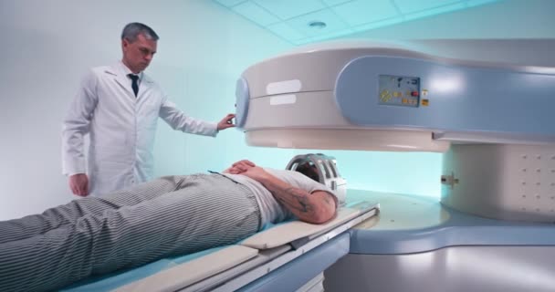 Médico maduro terminando procedimiento de resonancia magnética para el paciente — Vídeos de Stock