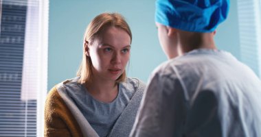 Anne, oğluna onkoloji hastanesinde tedavi öncesi eğitim veriyor.