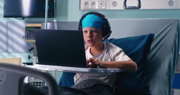 Gamer en auriculares jugando en la sala de hospital — Vídeo de stock