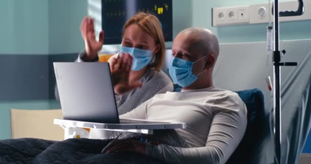 Patiënt en vrouw in masker maken van videogesprek in kliniek — Stockvideo