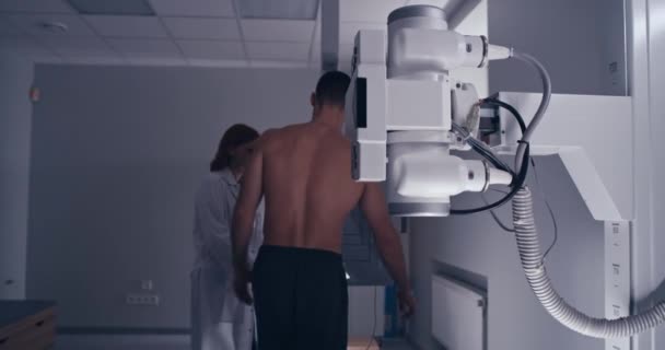 Volwassen arts beginnen X ray scannen voor mannelijke patiënt — Stockvideo
