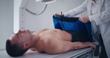 Ekin doktoru adamı göğüs röntgeni için hazırlıyor.