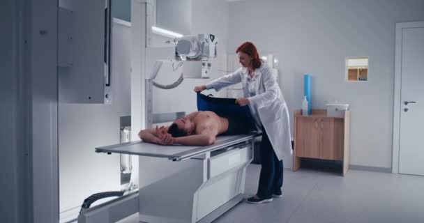 Vrouwelijke arts doet borst X-ray scan van mannelijke patiënt — Stockvideo