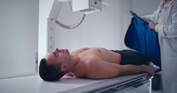 Crop medical practitioner initiëren X ray scan van mannelijke patiënt — Stockvideo