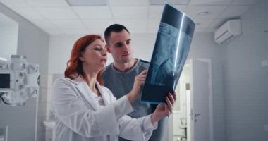 Olgun doktor hastaya röntgen taraması gösteriyor