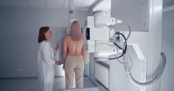Starší lékař připravuje pacientku na rentgen hrudníku — Stock video