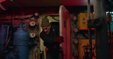 Erkek teknisyenler gemi motorunu tamir etmek için acele ediyorlar.