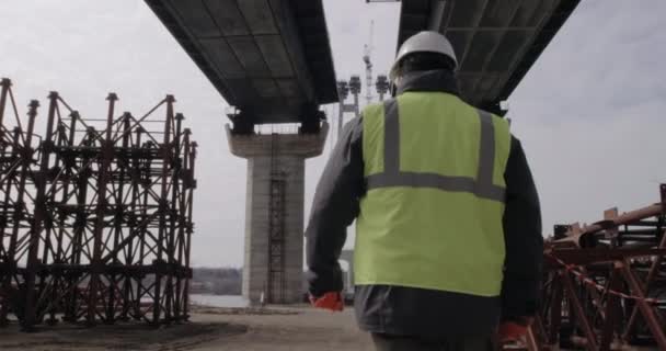Ingeniero masculino caminando bajo puente — Vídeos de Stock