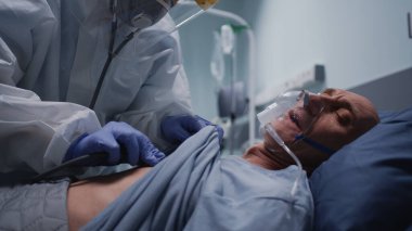 Doktor kıdemli hastanın akciğerlerini kontrol ediyor.