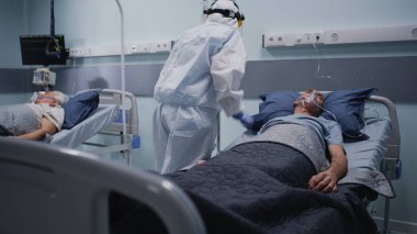 Tıbbi uzman yaşlı hastayı COVID zatürresi ile kontrol ediyor.