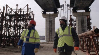 Köprü altında yürüyen erkek inşaatçılar