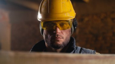 Erkek marangoz iş sırasında şapkasını düzeltiyor.