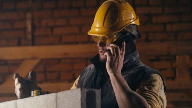 İnşaat alanında telefona cevap veren adam.