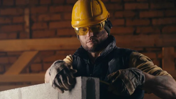 Constructor masculino que mide la pared de ladrillo — Foto de Stock