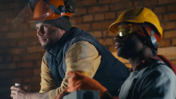 Diversos constructores hablando durante la pausa para el almuerzo — Foto de Stock