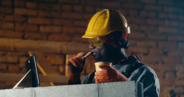 Zwarte bouwer maakt videogesprek tijdens lunchpauze — Stockvideo