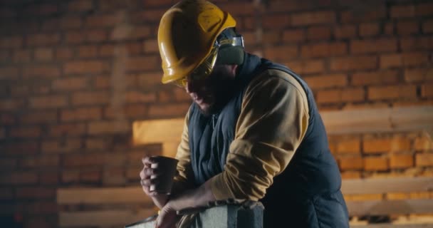 Hombre bebiendo bebidas calientes en el sitio de construcción — Vídeo de stock