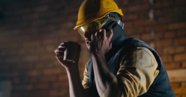 Constructor masculino hablando en smartphone durante la pausa para el almuerzo — Vídeos de Stock