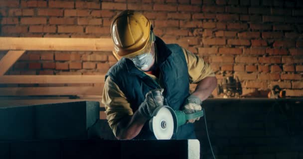 Male builder in respirator cutting wall — Stock Video