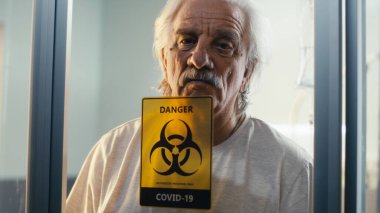 COVID koğuşundaki cam duvarın arkasındaki kıdemli hasta.