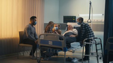 Doktor ve ailesi klinikte yaşlı bir adamı ziyaret ediyor.