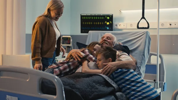 Famiglia felice visita uomo anziano in ospedale — Foto Stock