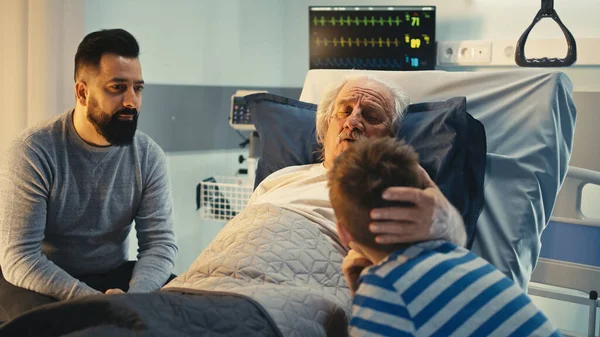 Homem sênior falando com filho e neto no hospital — Fotografia de Stock