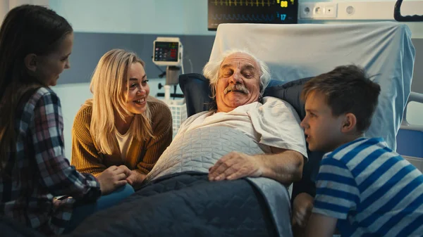 Senior patient speaking with daughter and grandchildren in hospital — Stock Photo, Image