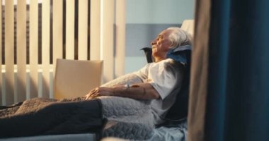 Hastanede yatağında yalnız yatan yaşlı bir hasta.