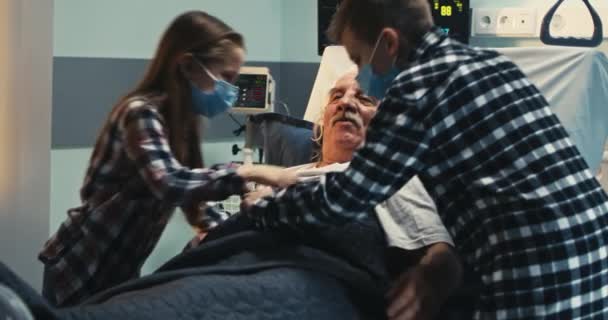 Пожилой мужчина обнимает семью в больнице — стоковое видео