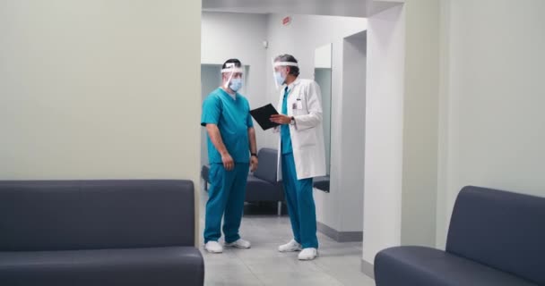 Asian doctor in face shield calling colleagues in hurry — Stock Video