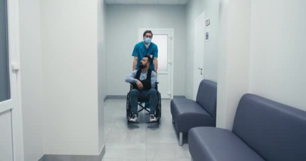 轮椅上的残疾男病人在走廊与医生交谈 — 图库视频影像