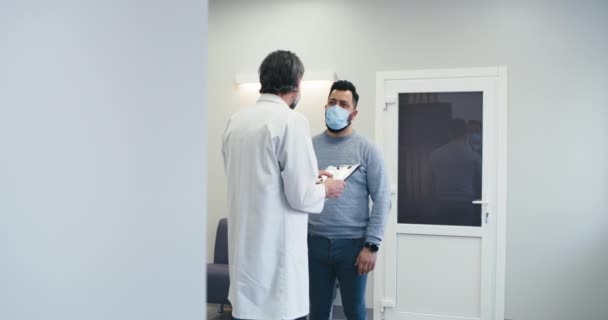 Médecin masculin parlant avec le patient dans le couloir de l'hôpital — Video