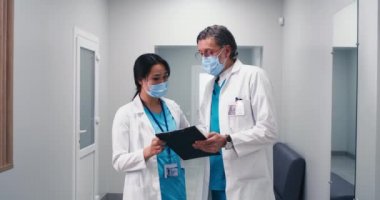 Çeşitli doktorlar koridorda verileri tartışıyor