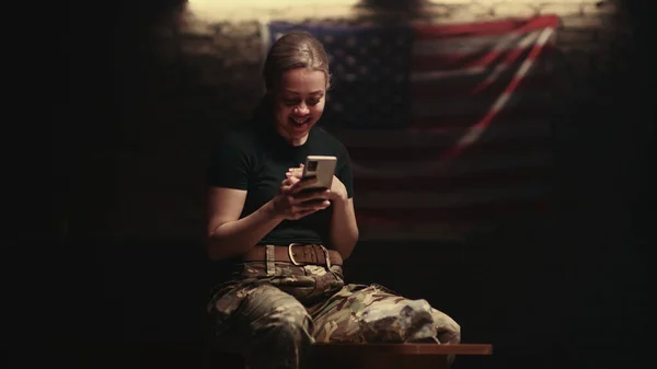 Memnuniyetle bayan asker bankta oturuyor ve video çağrısı yapıyor. — Stok fotoğraf