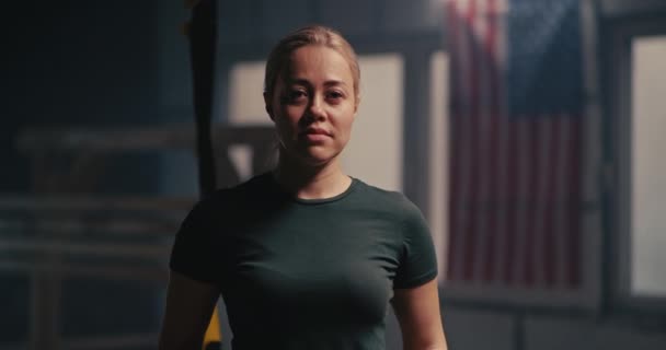 Stærk sportskvinde kigger på kamera i gymnastiksalen – Stock-video